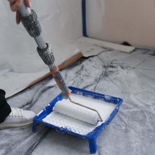 travailleur-de-la-construction-a-l-aide-d-un-rouleau-a-peinture